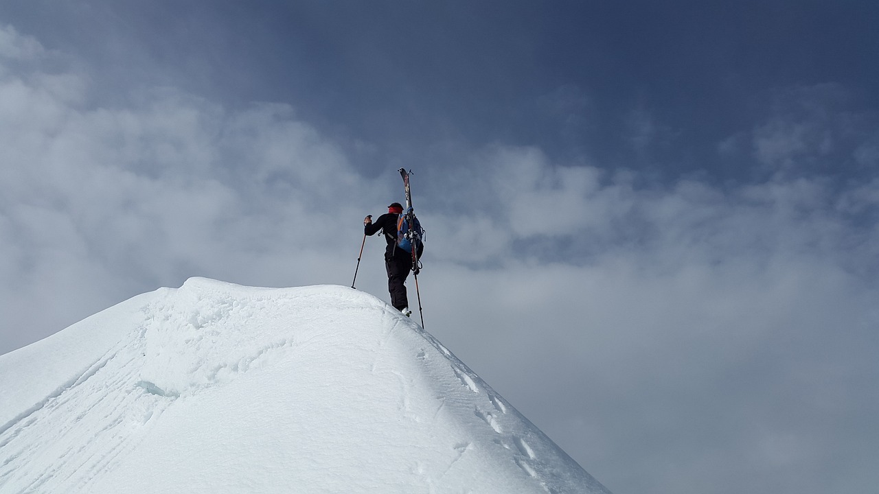 Mann auf Bergspitze im Schnee - Jahreswechsel